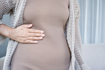 woman holding her right side stomach in pain. Concept of abdominal ache, liver issues, gallstones, or appendicitis. 
