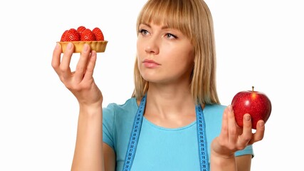 Woman comparing strawberry tart and red apple. Choice between healthy options showcases food preferences. Bright atmosphere highlights culinary decision-making process.