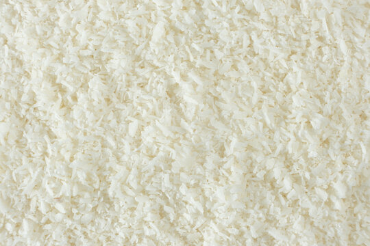 Background texture of white desiccated coconut flakes top view