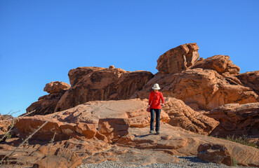 Woman walking on the red rocks at Valley of Fire State Park. Nevada, USA.