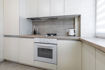 Modern kitchen interior with white minimalist cabinets and appliances