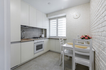 Bright modern kitchen and dining area with white furniture