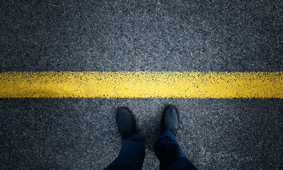 Man standing on asphalt road with the yellow line