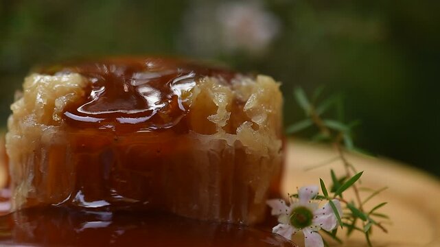 Manuka honey, honeycomb and flowers on natural background.