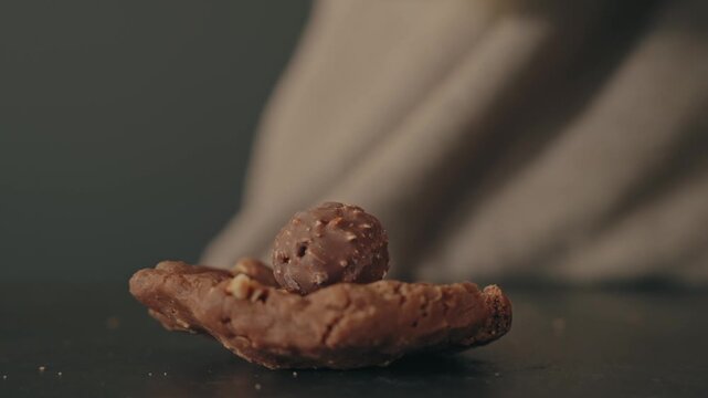 Hands shape chocolate cookie dough with two spoons in close up