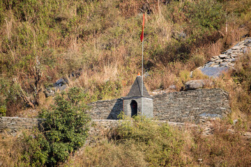 Obraz premium Ancient structure at a hillside location with a flag flying above in daylight
