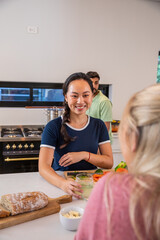 Diverse friends preparing breakfast on white quartz island with artisanal bread and juice