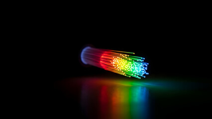 A bundle of colorful fiber optic cables glowing in the dark