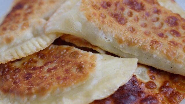 New crunchy bites, Fried chebureks with crispy edges, Homemade chebureks featuring flavorful textured crust, Crispy fried chebureks with savory textured outer layer