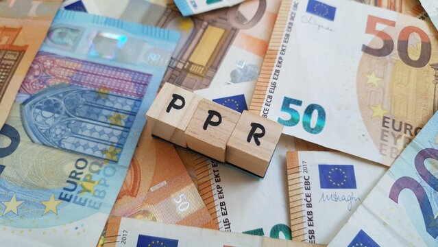 PPR acronym made of wooden letter cubes on pile of Euro banknotes.Plano Poupan&ccedil;a Reforma (Pension Savings Plan)