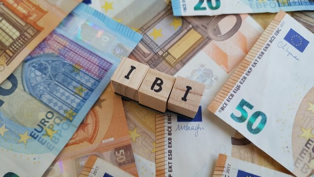IBI acronym made of wooden letter cubes on pile of Euro banknotes. Imposto sobre a Propriedade Imobili&aacute;ria (Real Estate Property Tax)