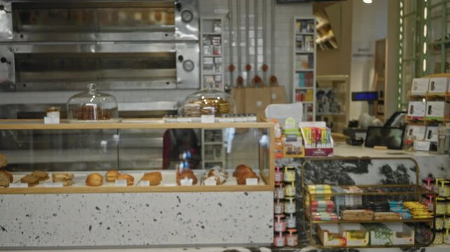 Bakery counter with pastry display and glass case, softly defocused shop background; background backdrop copyspace backplate.