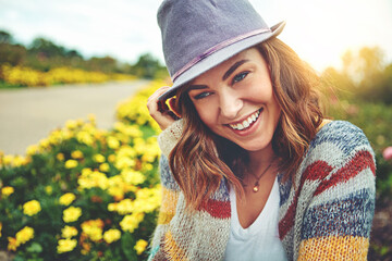 Fototapeta premium Thinking, woman and happy with sunhat outdoor for travel, spring adventure and holiday trip. Smile, female person and sightseeing nature with floral daisies, sunshine or vacation reflection in meadow