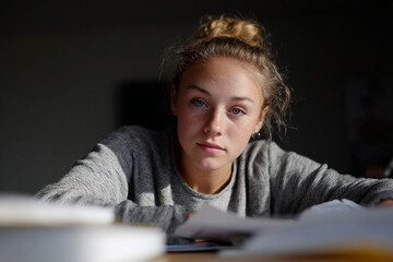 Student focused on completing homework at a desk.