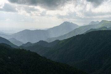 Obraz premium The mountains are covered in lush green trees and the sky is cloudy
