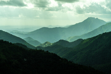 Obraz premium The mountains are covered in lush green trees and the sky is cloudy