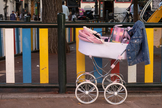 carro de bebe color rosa en un parque infantil.