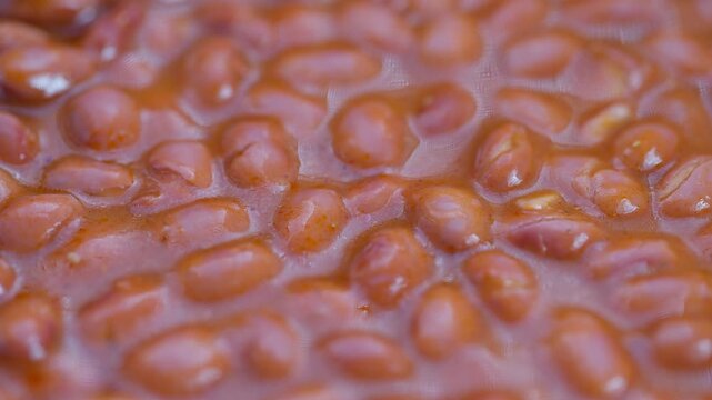 Glossy cooked beans macro shot, Detailed macro image of glazed red beans in sauce, Intimate view of simmering red beans with rich glossy coating and textured surface