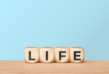 Life growth concept with letter cubes on light blue background