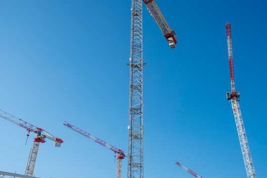 Crane construction industry equipment sky engineering lifting boom infrastructure progress with tall tower machinery against clear blue backdrop