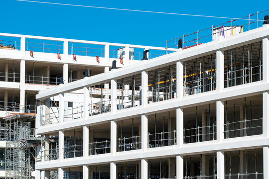 Construction building framework architecture concrete structure development commercial columns progress in modern office project under blue sky