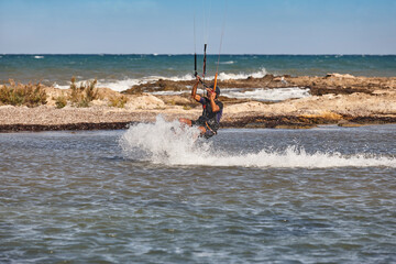 Mature man practicing kitesurfing. Aquatic sport. Athletic healthy senior