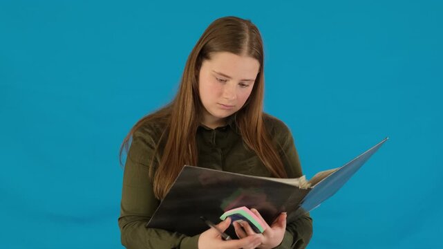 Disappointed schoolgirl flipping through pages of folder with school tasks. Woman shocked by overwhelming amount of homework slow motion