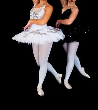 Dancers contrasting odette and odile characters, presenting elegant movements and duality of good and evil on stage