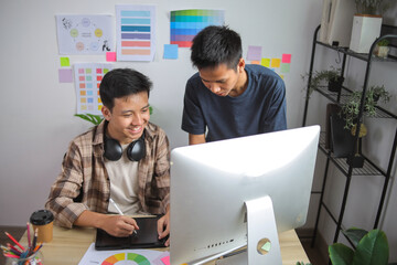 Two Young Asian Male Designers Working Together, Discussing Color Choices