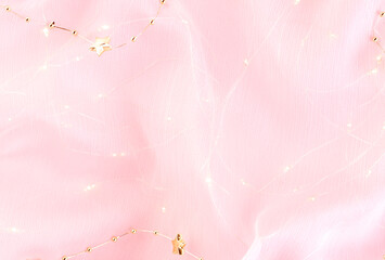 Pink glowing textile background, Christmas holiday backdrop.Shining texture.Valentine's backdrop. Mother's day wallpaper.