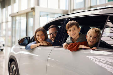 Happy family buying new car in auto salon.