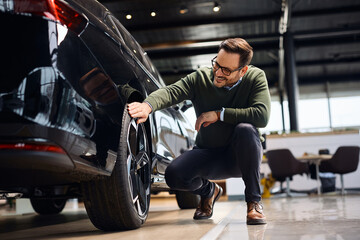 Happy man buying new vehicle at car dealership. © Drazen