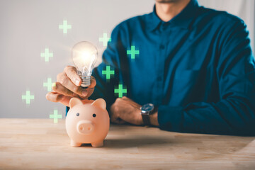 Financial innovation idea for piggy bank money energy investment saving, man holding glowing lightbulb helps save retirement finance growth with green positive plus signs around