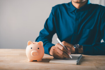 Piggy bank saving for education, college learning and career growth, man writing notes in notebook for financial planning, investment for student success and future wealth plans