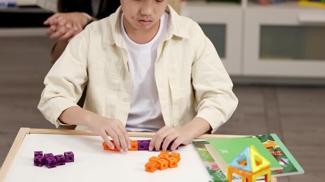 Young Boy Sorting Colorful Math Manipulatives in a Montessori Classroom