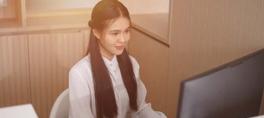 A female employee is working in the clinic's patient reception area.