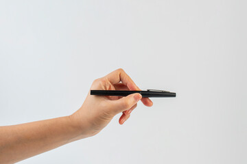 A black pen in hand against a white background.