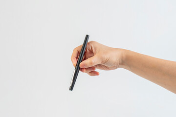 A black pen in hand against a white background.