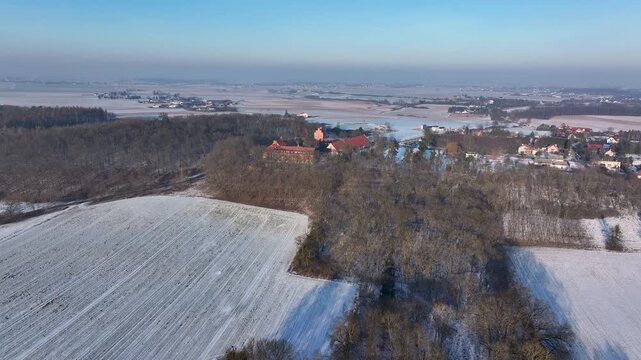 Aerial Zamek Bierzgłowski castle Poland 1 forward tilt. Medieval Castle. One of oldest defensive structures, built 1300's. Brick Gothic monastery castle Teutonic Knights. Historical buildings, farms.