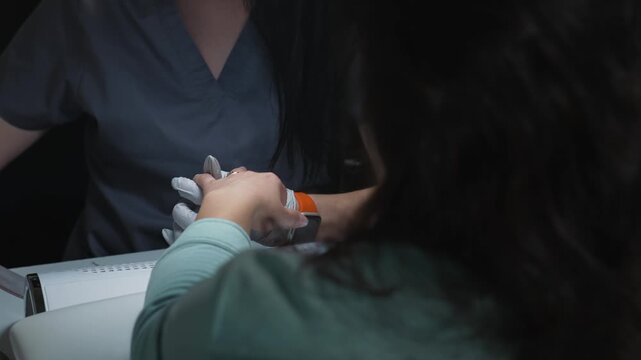 Forming acrylic nail shape during manicure procedure using salon file and professional equipment
