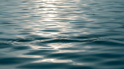 Serene aquatic reflections on the gently rippling surface of sunlit water, capturing a calm and tranquil liquid texture for background use
