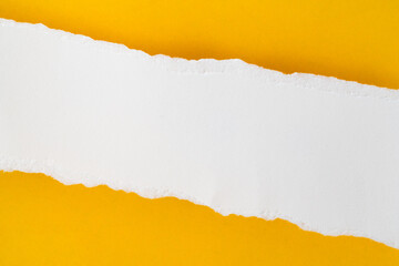 uneven torn blank white paper on grunge yellow paper, top view