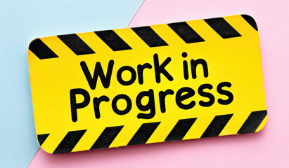Yellow work in progress sign with black stripes on colorful background