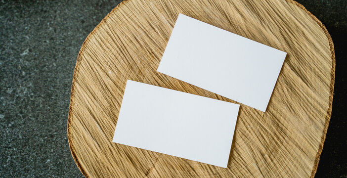 Blank business cards placed on a natural wooden surface with soft light and shallow depth of field. Clean mockup for branding, identity design and corporate presentation.
