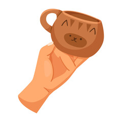 Obraz premium A hand holding a brown coffee cup with a cute cat face design, cartoon style on a white background. Concept of cozy and playful drinkware. Vector illustration