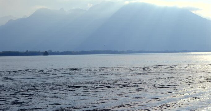 hydrofoil surfer gliding on Lake Geneva against misty Alps mountains