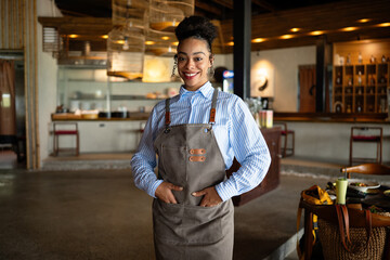 Portrait of beautiful young barista, african american woman is an employee standing in coffee shop