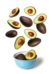 Ripe green and brown avocados falling into a ceramic bowl