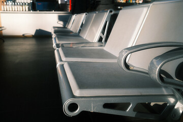 Row of empty metal seats or waiting bench at a train station platform