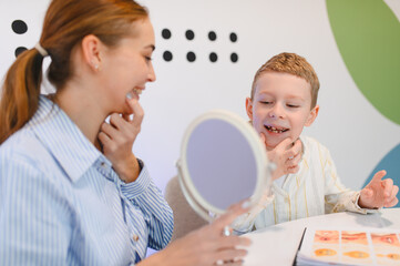 Speech therapist working with boy on articulation skills